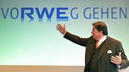 Jürgen Großmann gestikuliert vor dem RWE-Logo