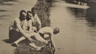 Soldaten mit nackten Oberkörpern an einem Fluss