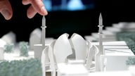 Fingerspitze auf einem Modellminarett der geplanten Moschee in Ehrenfeld