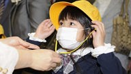 Japanisches Kind trägt einen Mundschutz