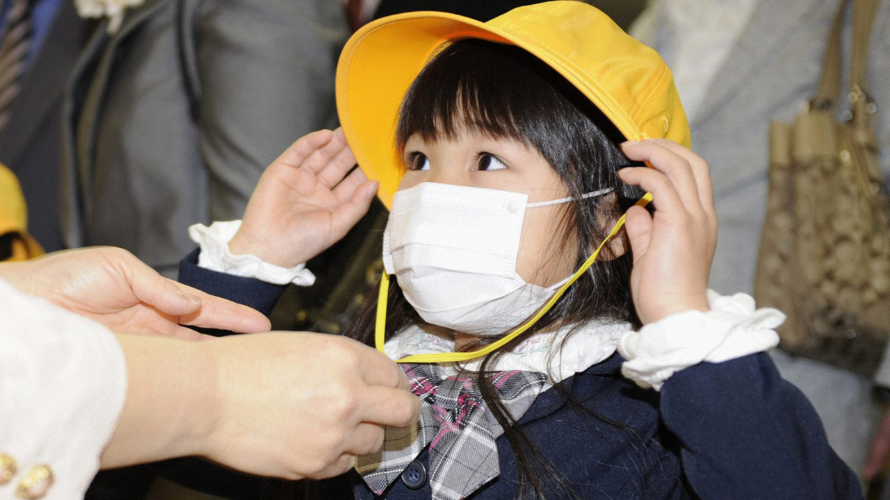 Japanisches Kind trägt einen Mundschutz