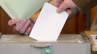 Ein Bürger wirft seinen Wahlzettel in eine Wahlurne