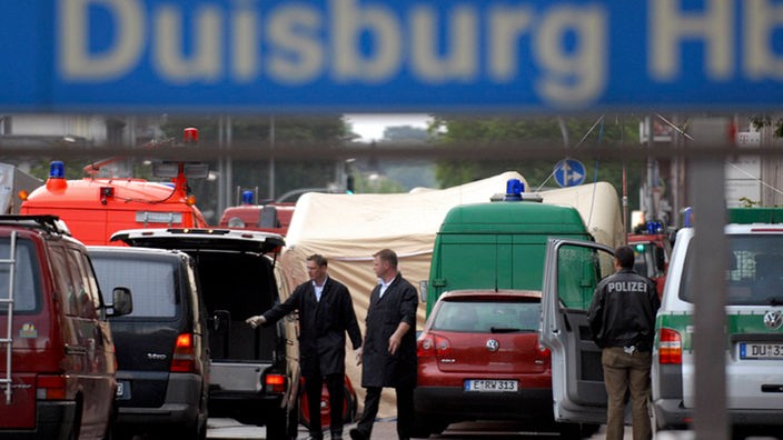 Zwei Bestatter in Duisburg zwischen Fahrzeugen am Tatort in der Nähe des Hauptbahnhofes 