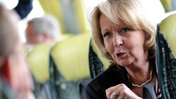 Hannelore Kraft (SPD) spricht während einer Busfahrt mit einem Journalisten