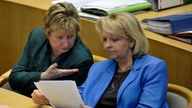 Hannelore Kraft und Sylvia Loehrmann unterhalten sich im Landtag bei einer Plenumssitzung