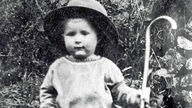 Johannes Rau als Kind mit einem Wanderstock und einem übergroßen Hut
