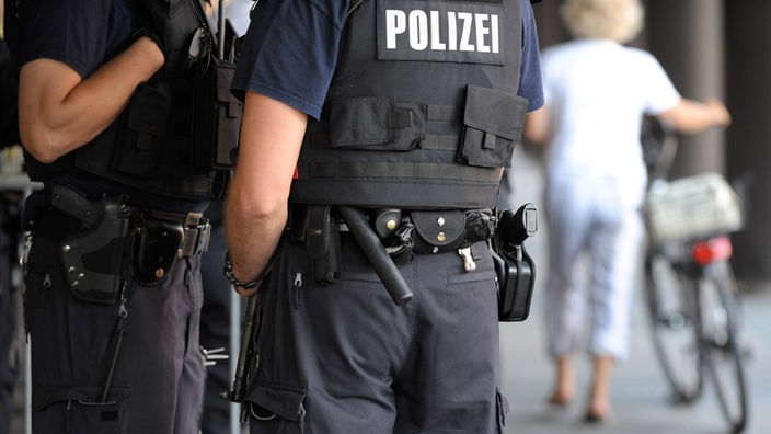 Polizisten mit Waffen und Schlagstöcken