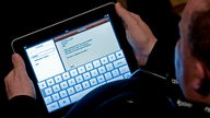 Besucher des Kongresses re:publica benutzt einen Tablet-PC