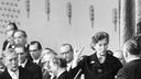 Schwarz-weiß-Aufnahme: Elisabeth Schwarzhaupt wird durch den Bundestagspräsidenten Eugen Gerstenmaier als Bundesministerin vereidigt., hinter ihr eine Gruppe Männer in Anzügen