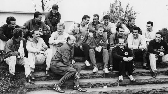 Gruppenfoto deutsches Nationalteam 1962 mit Trainern Herberger und Schön, auf einer Treppe sitzend 