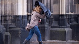 Eine Frau kämpft mit einer Sturmböe