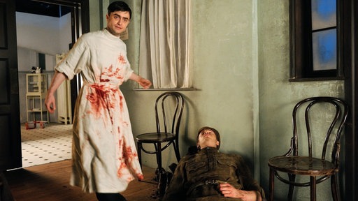 Der junge Doktor (l, Daniel Radcliffe) mit einem verwundeten Soldaten (Andy Apollo).