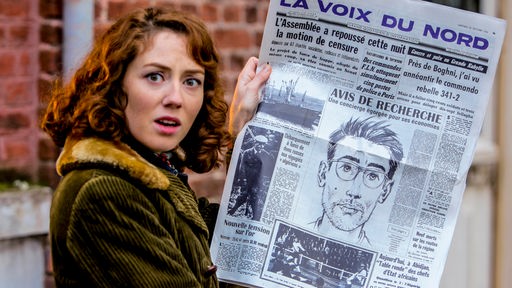 Alice (Blandine Bellavoir) liest schockiert die Zeitung.