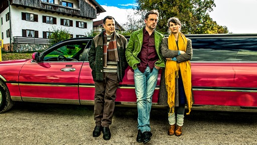 Geltinger Schwindler-Trio vor farbiger Stretchlimousine: Gerhard Wittmann (Karl Kainz), Sebastian Bezzel (Hubertus Hochstetter) und Kathrin von Steinburg (Iris Schranner)