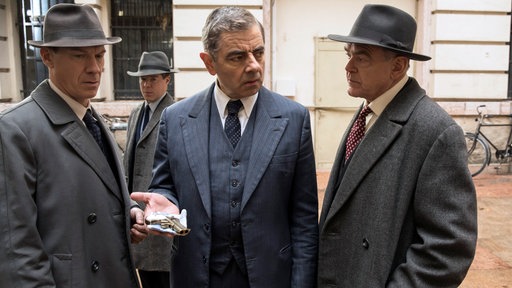 Inspektor Janvier (Shaun Dingwall, li.), Sergeant Bertinet (Stephen Wight, 2. v. li.), Kommissar Maigret (Rowan Atkinson) und Inspektor Grandjean (Kevin R McNally, re.) finden die Mordwaffe.