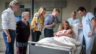 Peer (Dirk Borchardt, li.), Roswitha (Petra Kelling, 2. v. li.), Nora (Tanja Wedhorn), Kai (Lukas Zumbrock) und auch Jan Claasen (Thomas Schimanski) freuen sich mit Mandy (Morgane Ferru) über das Baby.