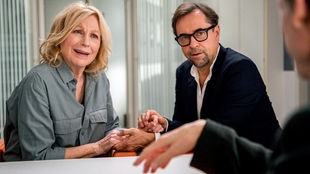 In "Kroymann", Folge 13, freuen sich prominente Homosexuelle (Maren Kroymann, links) über Agenturen, die Alibi-Eheleute (Jan Josef Liefers, rechts) vermitteln.
