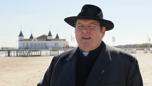 Pfarrer Braun (Ottfried Fischer) macht in seiner neuen Pfarrei auf Usedom einen Strandspaziergang.