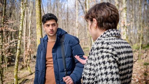 Eleni (Dorothée Neff, r.) versteht enttäuscht, dass Leander (Marcel Zuschlag, l.) den wahren Grund seiner Anwesenheit an der Quelle verschweigt.