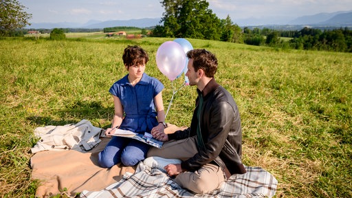 Eleni (Dorothée Neff, l.) und Julian (Tim Borys, r.) schreiben einen Brief an ihr ungeborenes Kind.