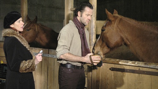 Cora (Claudia Wenzel, l.) muß ihren lästigen Helfer Andreas loswerden. Sie sperrt ihn in mit einem Pferd in eine Stallbox.