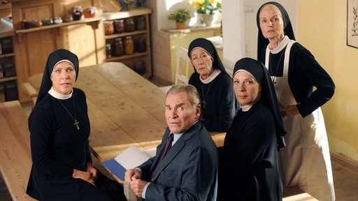 Schwester Hanna (Janina Hartwig), Bürgermeister Wöller (Fritz Wepper), Schwester Felicitas (Karin Gregorek), Mutter Oberin (Nina Hoger), Schwester Agnes (Emanuela von Frankenberg) schauen fassungslos, als das Kruzifix von der Wand fällt.