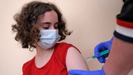Ein 13-jähriges Mädchen bekommt die Impfung.