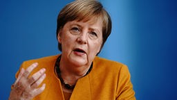 Angela Merkel mit erhobener Hand