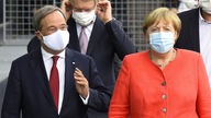 NRW-Ministerpräsident Armin Laschet (l.) und Bundeskanzlerin Angela Merkel, beide mit Schutzmaske, sich unterhaltend bei einem Spaziergang.