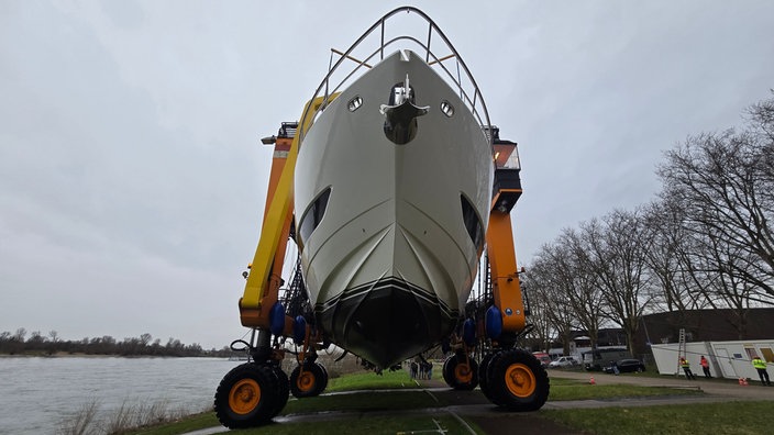 Yacht hängt an einem orangenen Kran 