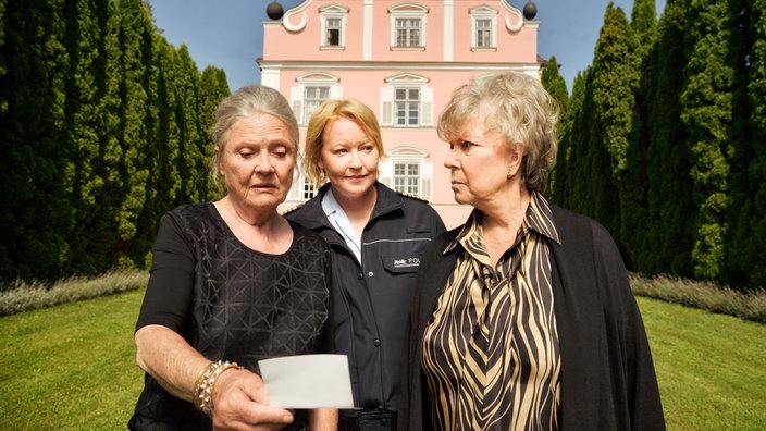 Ursula Wiesel (Cordula Trantow, l.) und Gertraud Bergmann (Grit Böttcher, r.) identifizieren Mechthild, die Mutter von Nele (Floriane Daniel, M.), als weitere Geliebte des ermordeten Alfred.