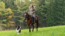 Rike (Klara Deutschmann) beim Ausritt mit Jacomo und ihrem Hund.