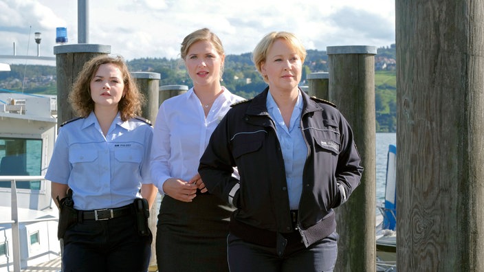 Nele (Floriane Daniel, r.) und Julia (Wendy Güntensperger, l.) machen sich mit der Hotelangestellten Daniela Dahlke (Laura Lippmann, M.) auf die Suche nach der verschwundenen Vanessa.