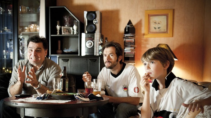 Alex, Murat und Paul sitzen im Dagdelen-Wohnzimmer