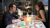 Alex und Josi sitzen sich an einem romantisch dekorierten Tisch gegenüber