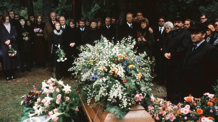 Auf Bennos Beerdigung nehmen Freunde und Nachbarn Anteil an seinem frühen Tod.