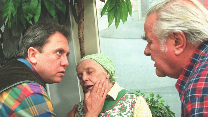 Beim Anblick Olafs (Franz Rampelmann, links) neuer Frau Mary, fällt Else (Annemarie Wendl) sofort in Ohnmacht. Egon (Wolfgang Grönebaum) ist verdutzt.