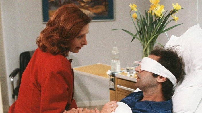 Biance (Annette Kreft) besucht Stefan Nossek (Dietrich Siegl) im Krankenhaus.
