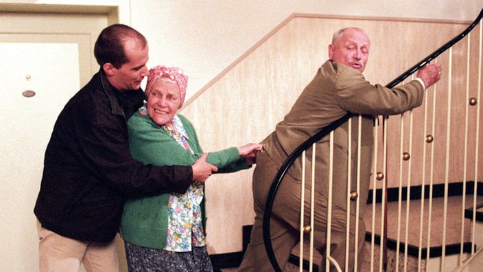 Carsten (Georg Uecker, links) rettet Onkel Franz (Martin Rickelt) vor Elses (Annemarie Wendl) Attacken.