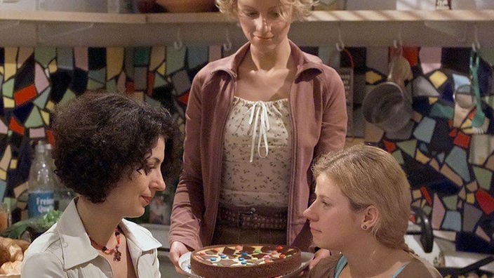 Das Ende einer Wohngemeinschaft: Carmen (Manja Schaar, Mitte) hat zum Tag des Auszugs einen Kuchen gebacken. Suzanne (Susanne Evers, links) und Nina (Jacqueline Svilarov) sind gerührt.