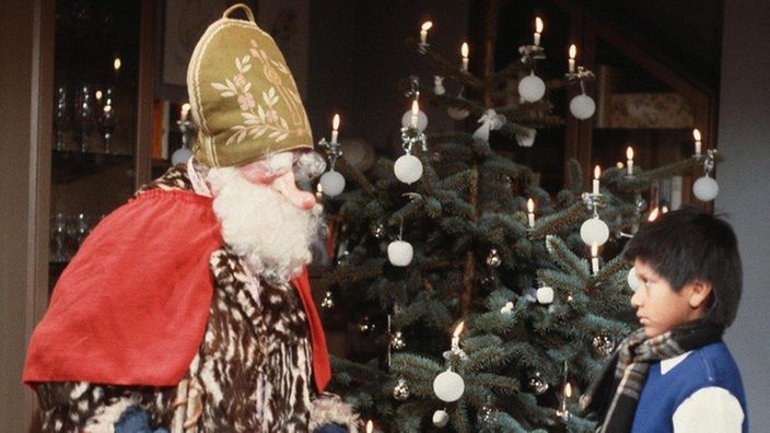 Der Weihnachtsmann (Annemarie Wendl) kommt zu Manoel (Marcel Komissin).