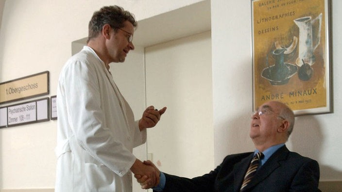 Dressler (Ludwig Haas, rechts) will von Dr. Jansen (Matthias Haase) alles über Hannelores Gesundheitszustand wissen.
