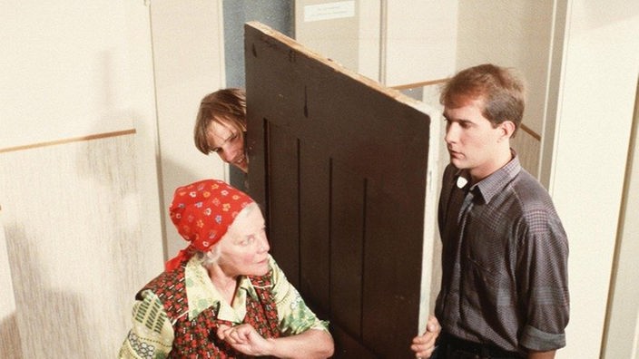 Else (Annemarie Wendl) beschimpft Carsten (Georg Uecker, rechts) und Zorro (Thorsten Nindel) im Hausflur.