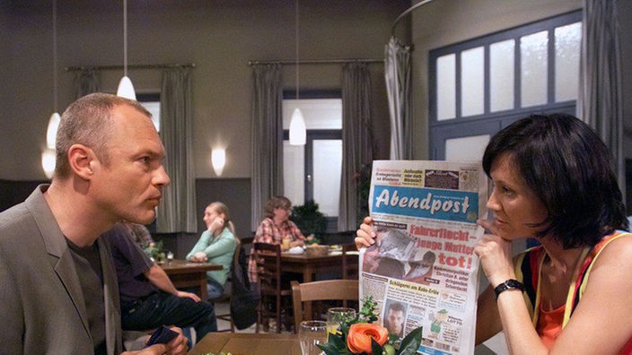 Entsetzen am Abend: Urszula (Anna Nowak) zeigt Brenner (Klaus Nierhoff) die druckfrische Abendzeitung mit dem Aufmacher, in dem es um ihn geht.