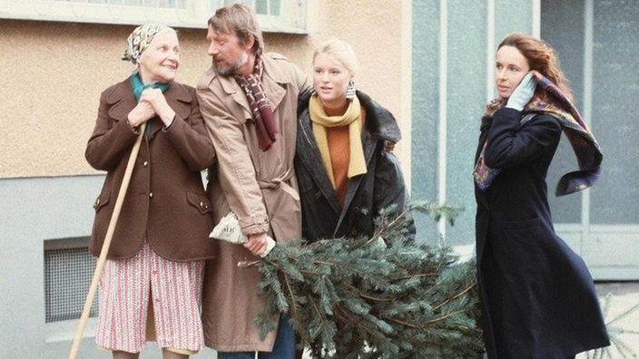 Franz (Raimund Gensel), Tanja (Sybille Waury) und Vera (Ria Schindler, rechts) bringen ihren Weihnachtsbaum nach Hause. Else (Annemarie Wendl, links) hat die Nase - wie immer - ganz vorn.