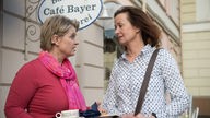 Gabi und Anna unterhalten sich vorm Café Bayer