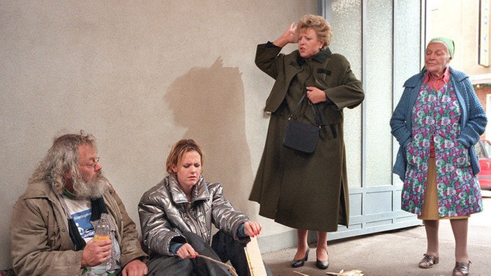Helga (Marie-Luise Marjan) ist entsetzt, Else (Annemarie Wendl, rechts) lacht sich ins Fäustchen: Pat (Giada Gray, li) ist aus der Beimer-Wohnung ausgezogen und hat ihr Lager mit Harry (Harry Rowohlt) in der Hofdurchfahrt aufgeschlagen.