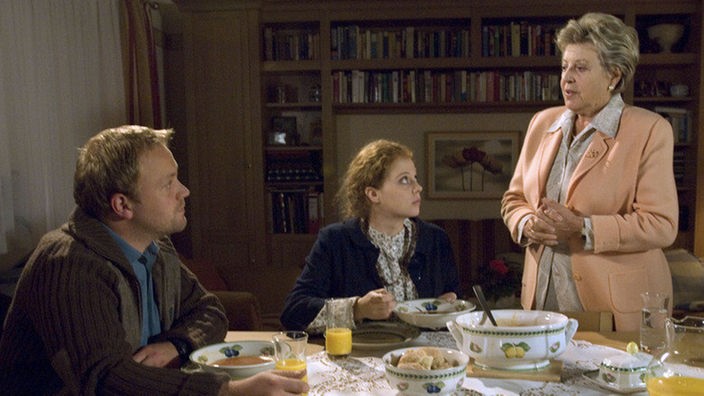 Helga (Marie-Luise Marjan, rechts) hat Nastya (Anja Antonowicz) und Klaus (Moritz A. Sachs) zum Essen eingeladen &#8211; nicht ohne Hintergedanken. Ihr ist die Beziehung seit langem ein Dorn im Auge.