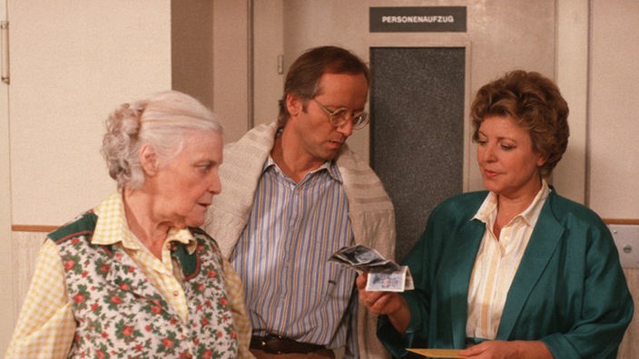 Helga (Marie-Luise Marjan, rechts) wundert sich über den unerwarteten Geldsegen im Briefkasten. Hans (Joachim Hermann) gibt sich unwissend.