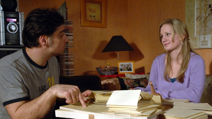 Lisa (Sontje Peplow) und Murat (Erkan Gündüz) schreiben Hochzeitseinladungen.